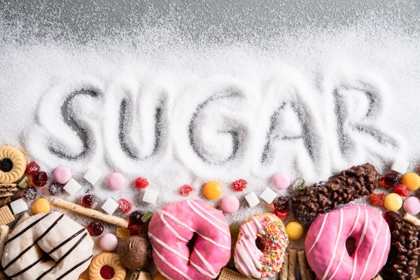 word sugar spelled out on table with donuts and candy