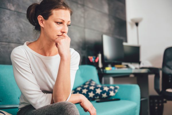 woman with anxiety sitting on couch